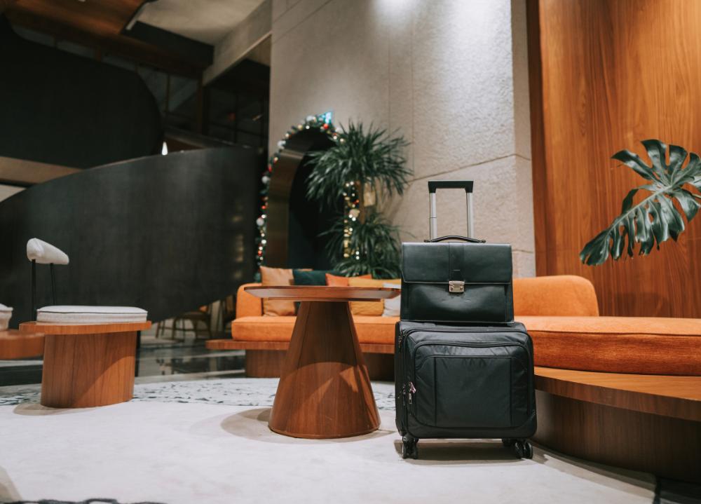 Hotel lobby with luggage, tables and chairs. 