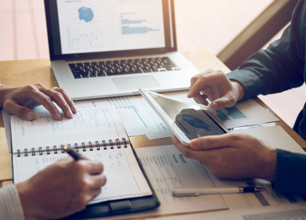 Two financial advisors reviewing financial reports at a desk