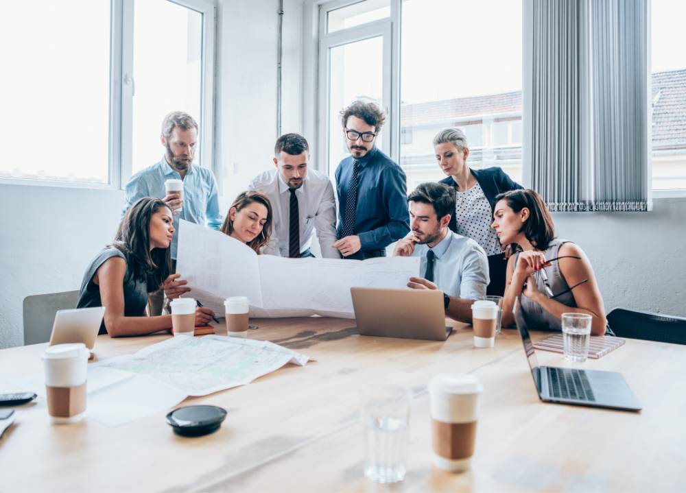 Marketing team sitting at desk analyzing graphs and data